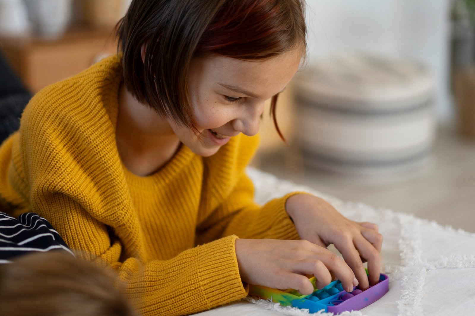 close-up-child-playing-with-pop-it-toy